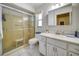 Bathroom featuring a shower with glass doors, vanity and window at 8420 Winding Wood Dr, Port Richey, FL 34668