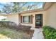 Exterior close up view of a front entrance with a storm door and decorative window shutters at 8420 Winding Wood Dr, Port Richey, FL 34668