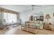 Bright living room featuring wood floors, floral-patterned furniture, and a ceiling fan at 8420 Winding Wood Dr, Port Richey, FL 34668