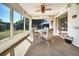 Sunroom area featuring carpet flooring and a table and chairs under a ceiling fan at 8420 Winding Wood Dr, Port Richey, FL 34668