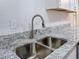 Close up on a stainless steel kitchen sink and granite counter, with a window nearby at 8528 Viva Via Dr, Hudson, FL 34667