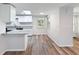 Well-lit kitchen featuring white cabinets, granite countertops, and wood-look floors at 8528 Viva Via Dr, Hudson, FL 34667