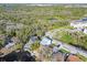Scenic aerial view of homes, water features, and road winding through a forest landscape at 8721 Old Post Rd, Port Richey, FL 34668