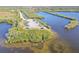 Aerial view of the coast with water and an area for recreation with lush greenery, picnic tables and parking at 8721 Old Post Rd, Port Richey, FL 34668