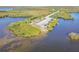 Aerial view of a serene waterfront area with a parking lot, covered picnic tables and lush greenery at 8721 Old Post Rd, Port Richey, FL 34668