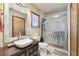 Bathroom with updated vanity, sink, toilet, and a glass-enclosed shower with marble-look tile at 8721 Old Post Rd, Port Richey, FL 34668