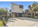 Three-story elevated home with spacious parking, fenced yard, and lush landscaping at 8721 Old Post Rd, Port Richey, FL 34668