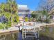 Waterfront home with a screened balcony, lush landscaping, and a private boat lift on a canal at 8721 Old Post Rd, Port Richey, FL 34668