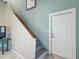 Hallway with stairs and white door with wooden door trim leading to the upper level at 8721 Old Post Rd, Port Richey, FL 34668