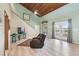 Cozy living room featuring vaulted ceilings, light-green walls, and access to a private balcony at 8721 Old Post Rd, Port Richey, FL 34668