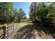 Spacious backyard featuring mature trees, partial fencing, and a house, creating a serene and inviting outdoor space at 9382 Wild Horse Trl, Brooksville, FL 34601
