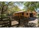 Wooden barn exterior, surrounded by a rustic wooden fence and shady trees on the horse property at 9382 Wild Horse Trl, Brooksville, FL 34601
