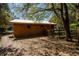 Well-maintained barn with a metal roof and wooden siding, nestled among mature trees on the property at 9382 Wild Horse Trl, Brooksville, FL 34601