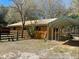 Exterior view of a wooden barn, complemented by a wooden fence and a convenient carport at 9382 Wild Horse Trl, Brooksville, FL 34601