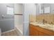Well-lit bathroom featuring a granite countertop, vanity and tub with tile and a decorative tile accent at 9382 Wild Horse Trl, Brooksville, FL 34601