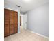 Neutral bedroom with tiled flooring, wood closet, and white door in the background at 9382 Wild Horse Trl, Brooksville, FL 34601