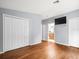 Spacious bedroom with hardwood floors, double closets, and a view into the bathroom at 9382 Wild Horse Trl, Brooksville, FL 34601