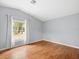 Light-filled bedroom features hardwood floors, neutral walls, and a large window with backyard views at 9382 Wild Horse Trl, Brooksville, FL 34601