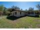 Exterior back view of home with a spacious yard and a sunroom at 9382 Wild Horse Trl, Brooksville, FL 34601