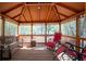 Cozy gazebo interior featuring bench seating and relaxing chairs, ideal for outdoor gatherings at 9382 Wild Horse Trl, Brooksville, FL 34601
