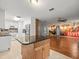 Open concept kitchen features island with granite countertop, tile flooring, and stainless steel appliances at 9382 Wild Horse Trl, Brooksville, FL 34601