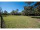 Expansive lawn area bordered by trees and fencing, offering plenty of space for outdoor activities at 9382 Wild Horse Trl, Brooksville, FL 34601