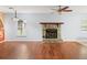 Living room featuring hardwood flooring, a stone fireplace, and natural light through a window at 9382 Wild Horse Trl, Brooksville, FL 34601