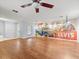 Spacious living room featuring hardwood floors, ceiling fan, and a sliding closet-door mural at 9382 Wild Horse Trl, Brooksville, FL 34601
