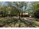 Property view with wooden barn, set among lush trees at 9382 Wild Horse Trl, Brooksville, FL 34601