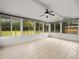 Spacious sunroom featuring tile flooring, windows providing natural light, and a fan at 9382 Wild Horse Trl, Brooksville, FL 34601