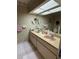 Bright bathroom featuring double sinks, ample counter space, and striped wallpaper at 11121 Linkside Dr # 11121, Port Richey, FL 34668