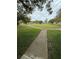 Well-maintained common area with lush greenery, mature trees, and connecting walkways at 11121 Linkside Dr # 11121, Port Richey, FL 34668