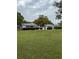 Community lawn with mature landscaping and white picket fences surrounding homes at 11121 Linkside Dr # 11121, Port Richey, FL 34668