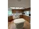 Well-lit kitchen features wooden cabinets, white appliances, and dining area with large table at 11121 Linkside Dr # 11121, Port Richey, FL 34668