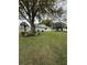 Large grassy backyard surrounded by mature trees and manicured landscaping at 11121 Linkside Dr # 11121, Port Richey, FL 34668