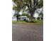 Well-maintained home with a lush green lawn, mature trees, and manicured landscaping at 11121 Linkside Dr # 11121, Port Richey, FL 34668