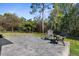 Relaxing paver patio with two chairs and a table offers serene views of the backyard at 11227 Lakeview Dr, New Port Richey, FL 34654