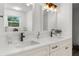 Bright bathroom featuring dual sinks with modern fixtures, vanity, and a window at 11227 Lakeview Dr, New Port Richey, FL 34654