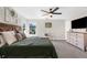 Spacious bedroom with decorative wall art, ceiling fan, and a dresser with television on top at 11227 Lakeview Dr, New Port Richey, FL 34654