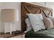 Close-up of a bed featuring a wood headboard, pillows, and a book on the nightstand at 11227 Lakeview Dr, New Port Richey, FL 34654