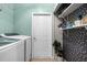 Practical laundry room with modern appliances, storage shelves, and stylish accent wall at 11227 Lakeview Dr, New Port Richey, FL 34654