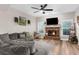 Inviting living room features a brick fireplace, ceiling fan, and plenty of natural light at 11227 Lakeview Dr, New Port Richey, FL 34654