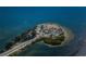 Aerial shot of a sandy island with lush trees and a connecting road, showing a coastal community at 120 Read St, Tarpon Springs, FL 34689