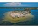 Aerial view of a sandy island featuring palm trees, a shelter, and clear waters, perfect for recreation at 120 Read St, Tarpon Springs, FL 34689