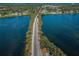 Aerial view of a road stretching between bodies of water, surrounded by lush trees and clear blue skies at 120 Read St, Tarpon Springs, FL 34689