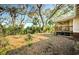 The backyard shows a covered porch and view of the yard with trees and other natural foliage at 120 Read St, Tarpon Springs, FL 34689