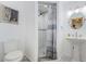 Bathroom with white tiled stand up shower, pedestal sink, and artwork on the walls at 120 Read St, Tarpon Springs, FL 34689