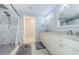 The bathroom features a double vanity, framed mirrors, a walk-in shower, and white marble styled tiling at 120 Read St, Tarpon Springs, FL 34689