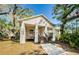 Charming two-story home featuring an inviting front porch, well-maintained landscaping, and mature trees, creating a picturesque setting at 120 Read St, Tarpon Springs, FL 34689