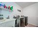 This laundry room has a utility sink, stainless steel washer and dryer, and an organized shelving unit at 120 Read St, Tarpon Springs, FL 34689